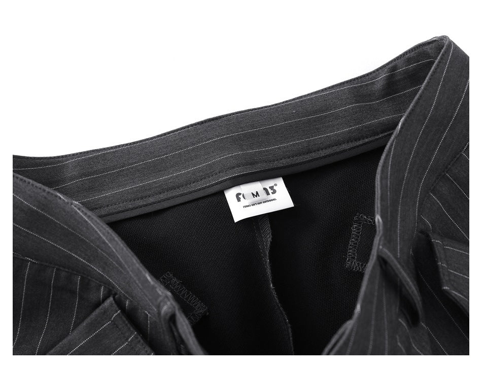 Inside waistband of charcoal pinstripe trousers with a small white clothing label visible.