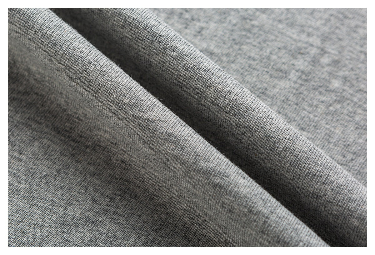 Close-up of heather-gray fabric draped into folds, showing its knit texture.
