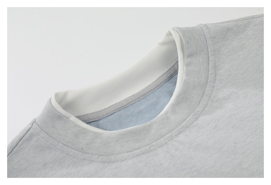 Close-up of a light gray T-shirt crew neck, showing the collar and inner neckline.