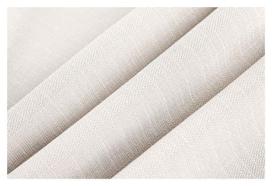 Close-up of light beige woven fabric arranged in soft diagonal folds.