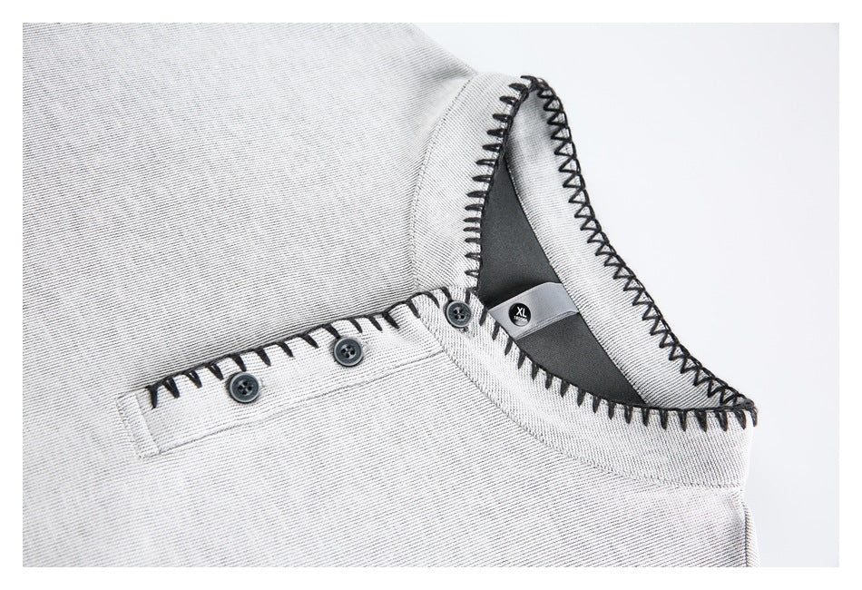 Close-up of a light gray shirt collar with black contrast stitching, a three-button placket, and an XL label.
