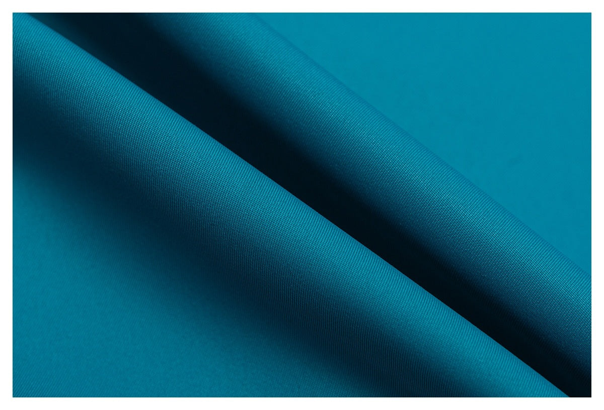 Close-up of turquoise fabric draped in folds, showing its fine surface texture.