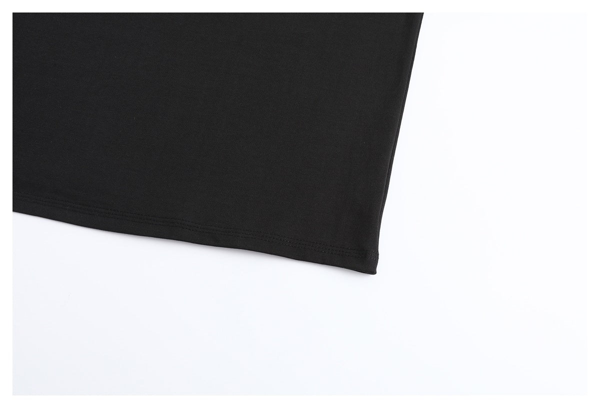 Close-up of the plain black T-shirt’s lower hem and stitching.