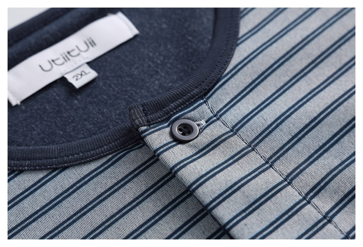 Close-up of the striped top’s dark neckline trim, single button, placket stitching, and sewn labels.