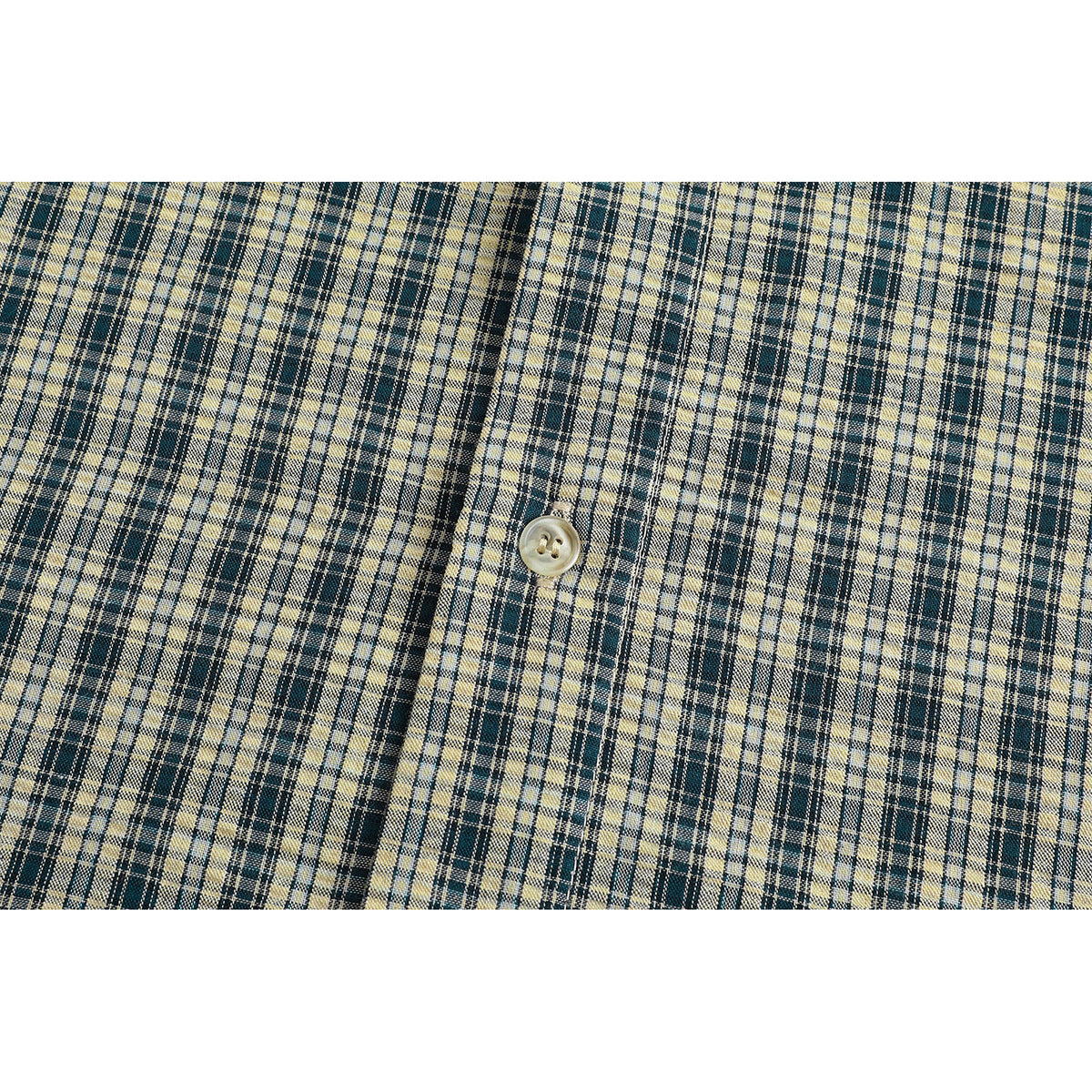 Extreme close-up of beige and navy plaid fabric with a pale button.