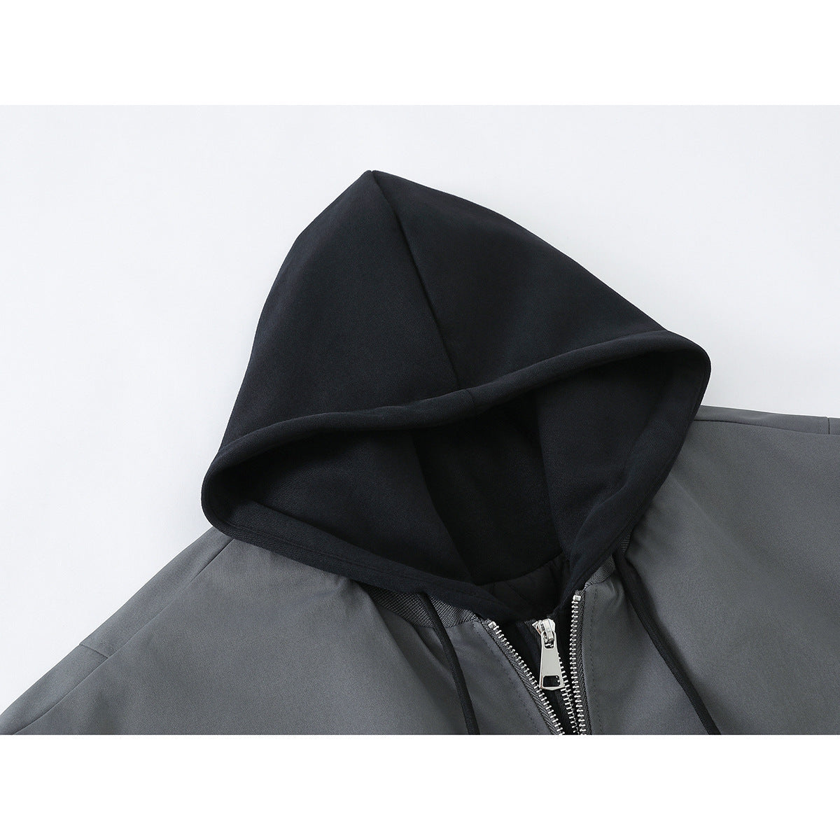 Close-up of a charcoal gray jacket with a black hood and silver front zipper.