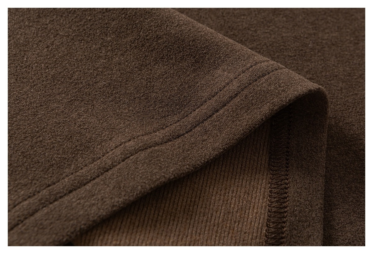 Close-up of the brown garment's folded hem, stitching, and interior seam finish.