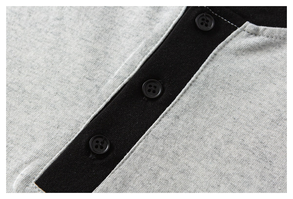 Close-up of a black three-button placket against heather-gray fabric.