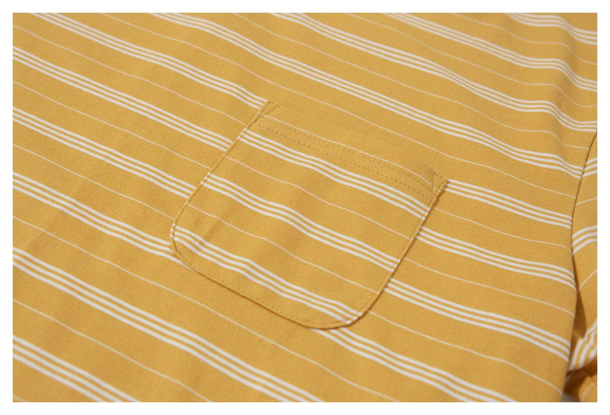 Close-up of a patch pocket on a mustard yellow T-shirt with thin white horizontal stripes.