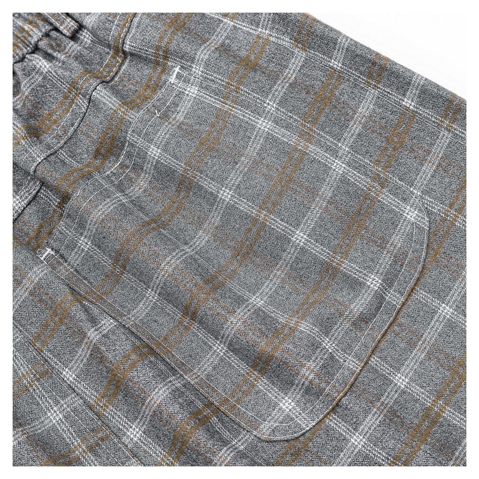 Close-up of a gray plaid garment showing a large stitched patch pocket and white and tan lines.