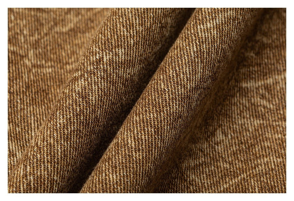 Macro view of brown-and-tan woven fabric folded to show its textured surface.