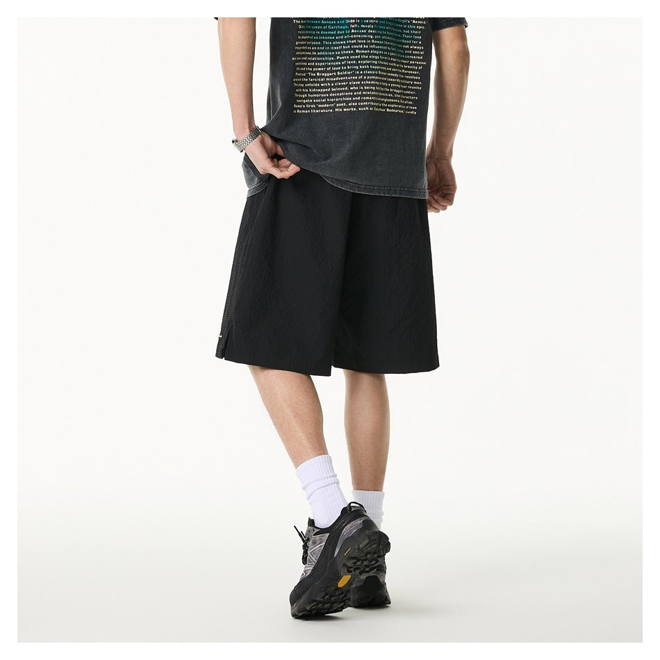 Rear view of a model wearing loose black shorts, framed by a narrow white border.
