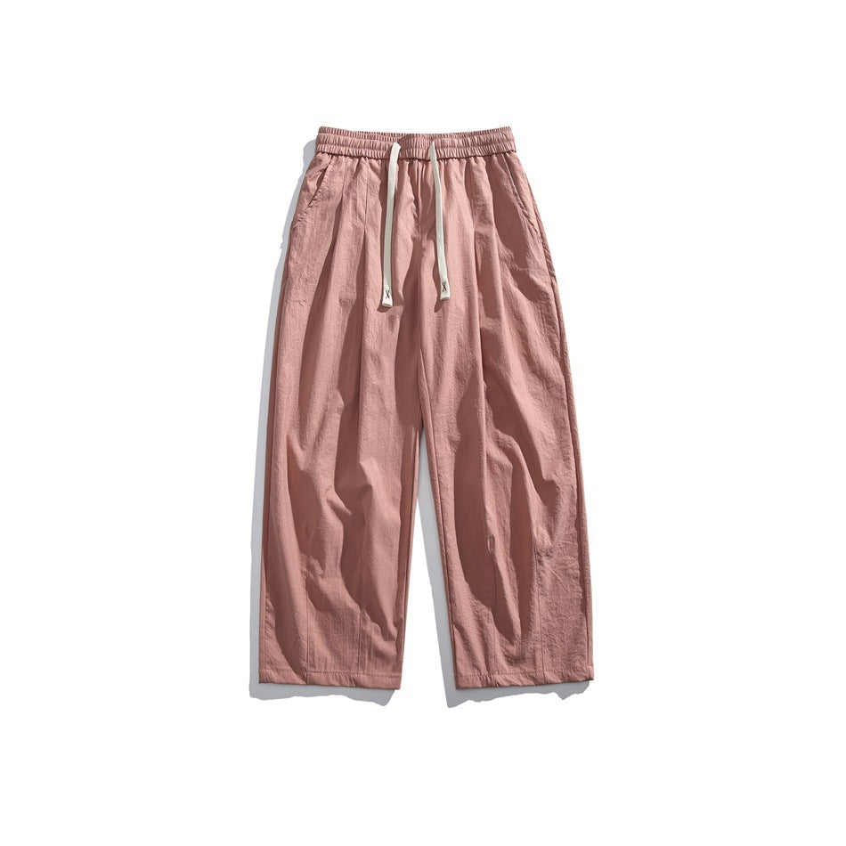 Front view of dusty rose wide-leg pants with an elastic waist, cream drawstrings, and side pockets.