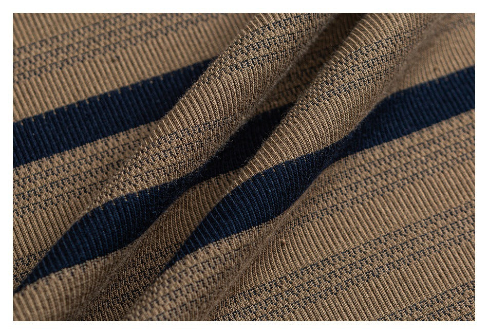 Macro view of textured tan knit fabric crossed by narrow navy stripes.