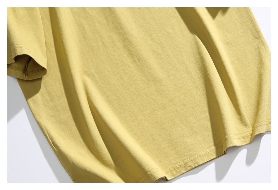Plain pale yellow short-sleeve T-shirt laid flat, with its blank front and bottom hem visible.