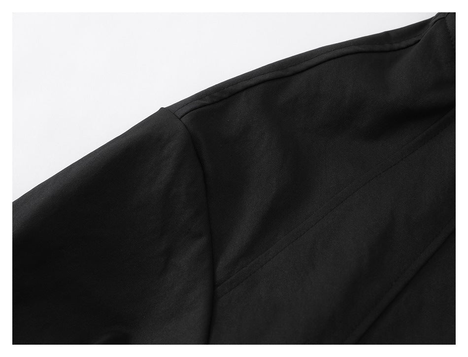 Close-up of the jacket's dark fabric, shoulder seam and sleeve construction.