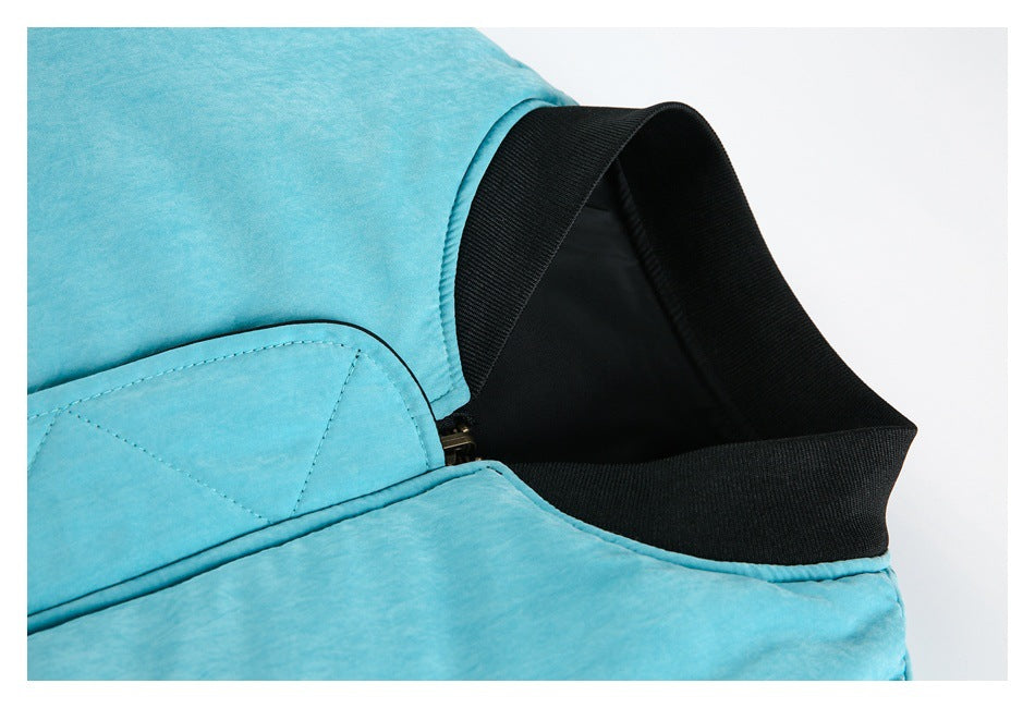Close-up of a turquoise jacket collar with black ribbed trim and a partially visible zipper.