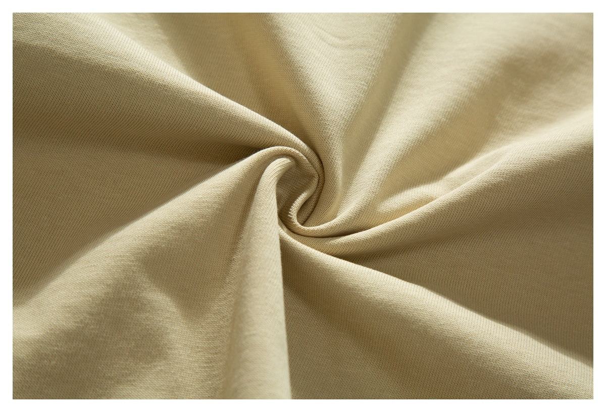 Close-up of light beige fabric gathered into a soft spiral fold.