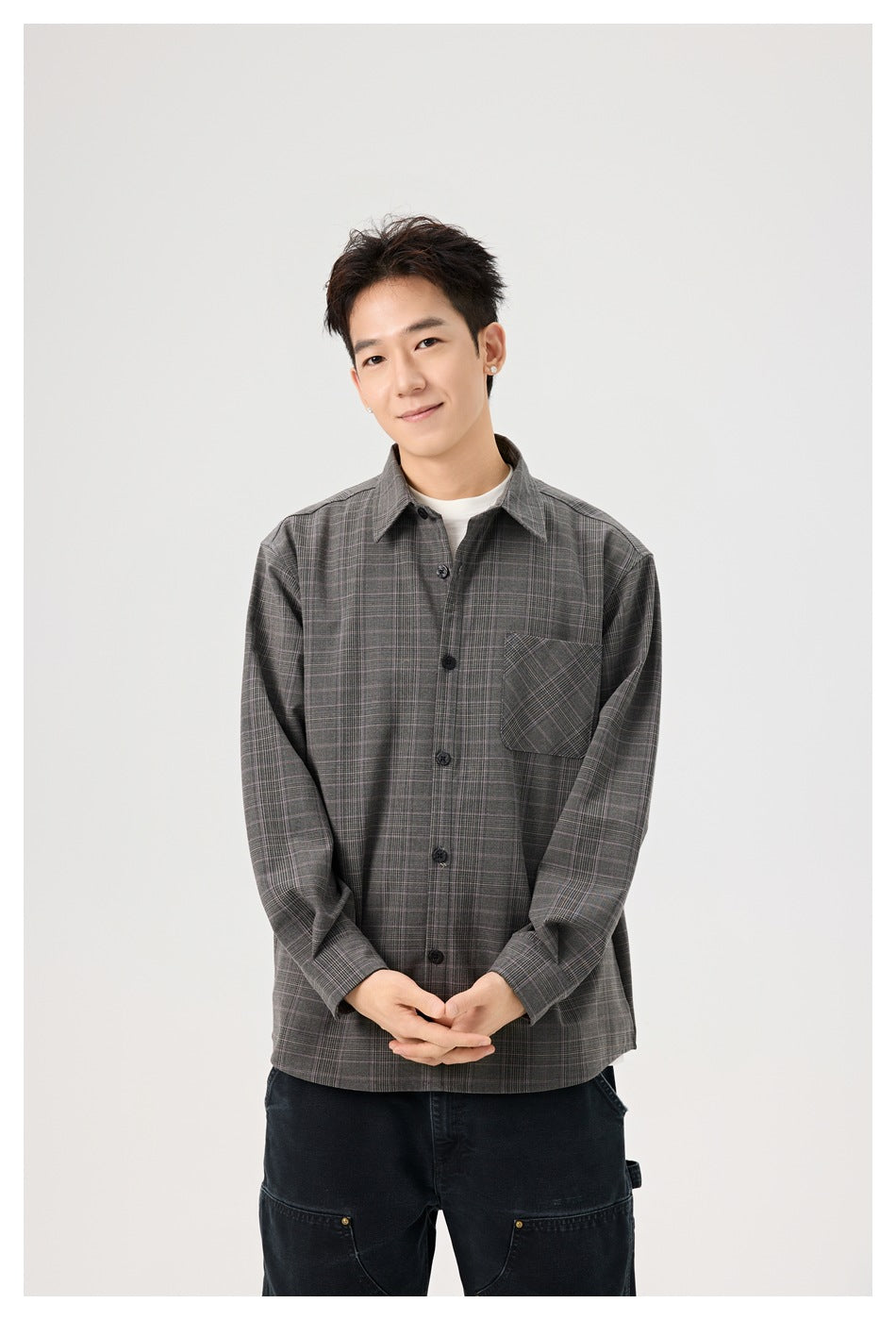 Model wearing a gray plaid button-up shirt with a chest pocket, shown from the front.