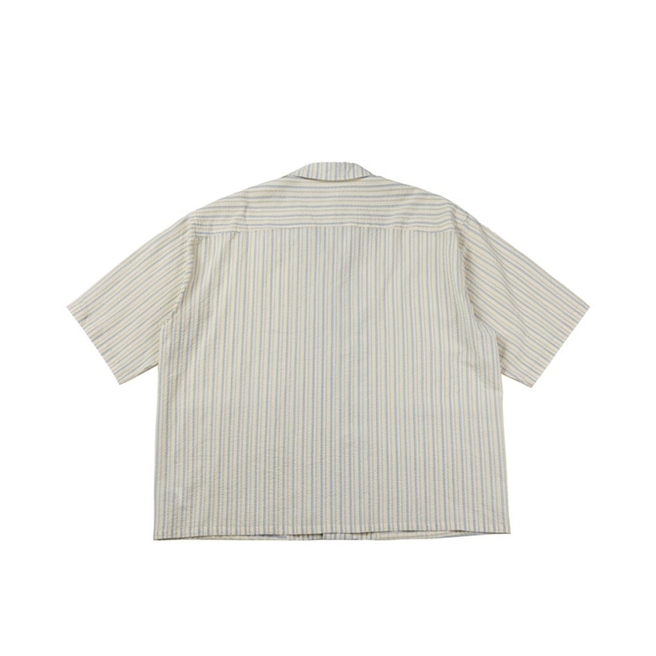 Back view of beige striped short-sleeve shirt with vertical stripes and shoulder yoke seam, flat lay
