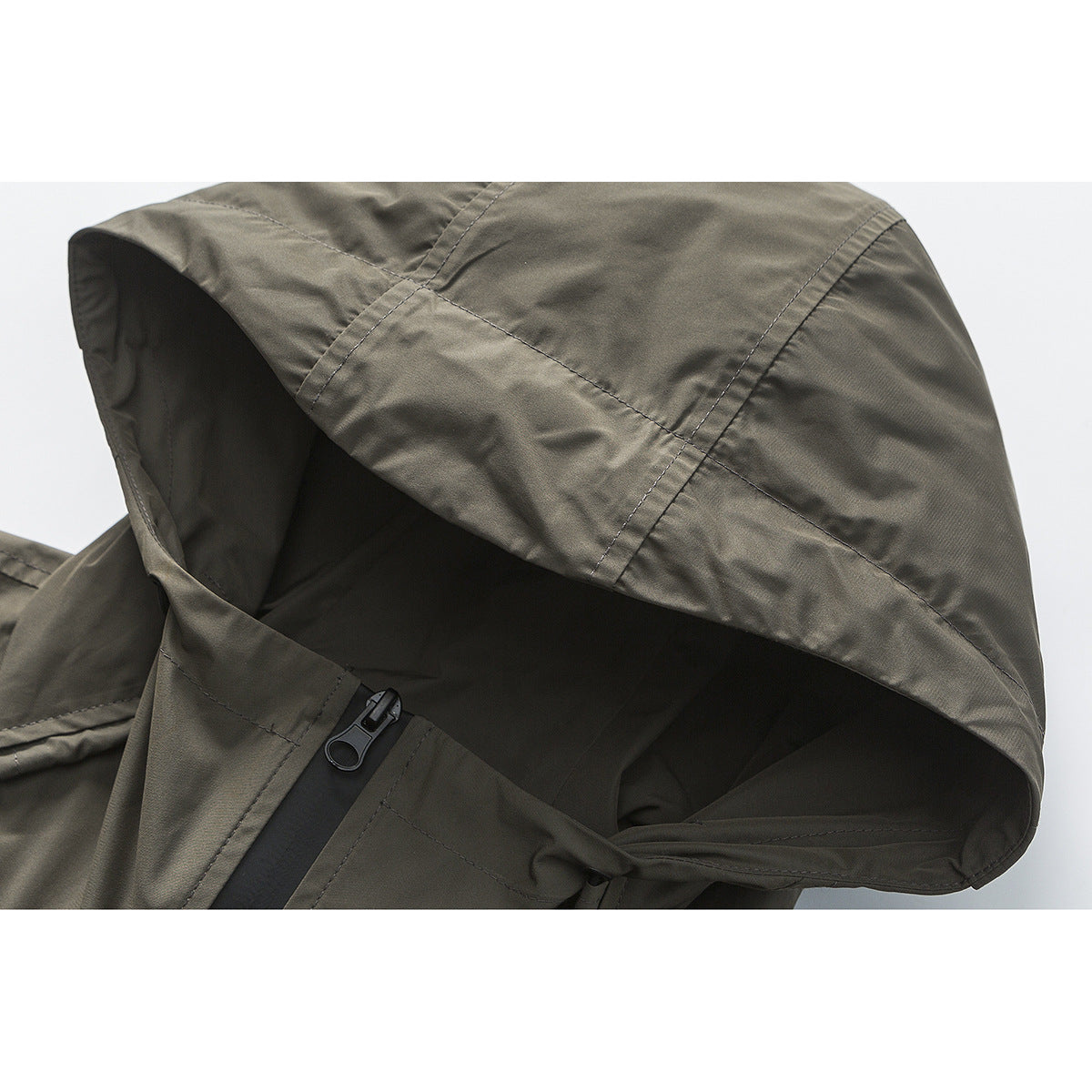 Close-up of an olive-gray jacket hood and black zipper.