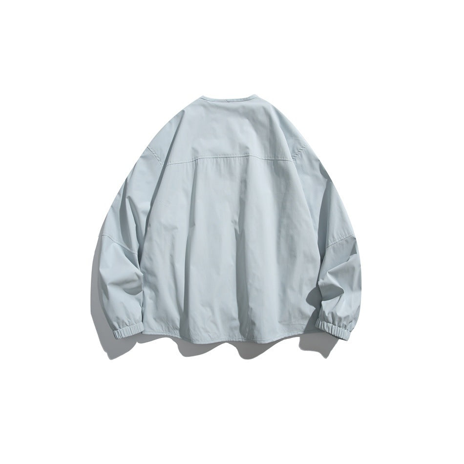 Back view of a pale blue jacket with a yoke seam and gathered elastic cuffs.