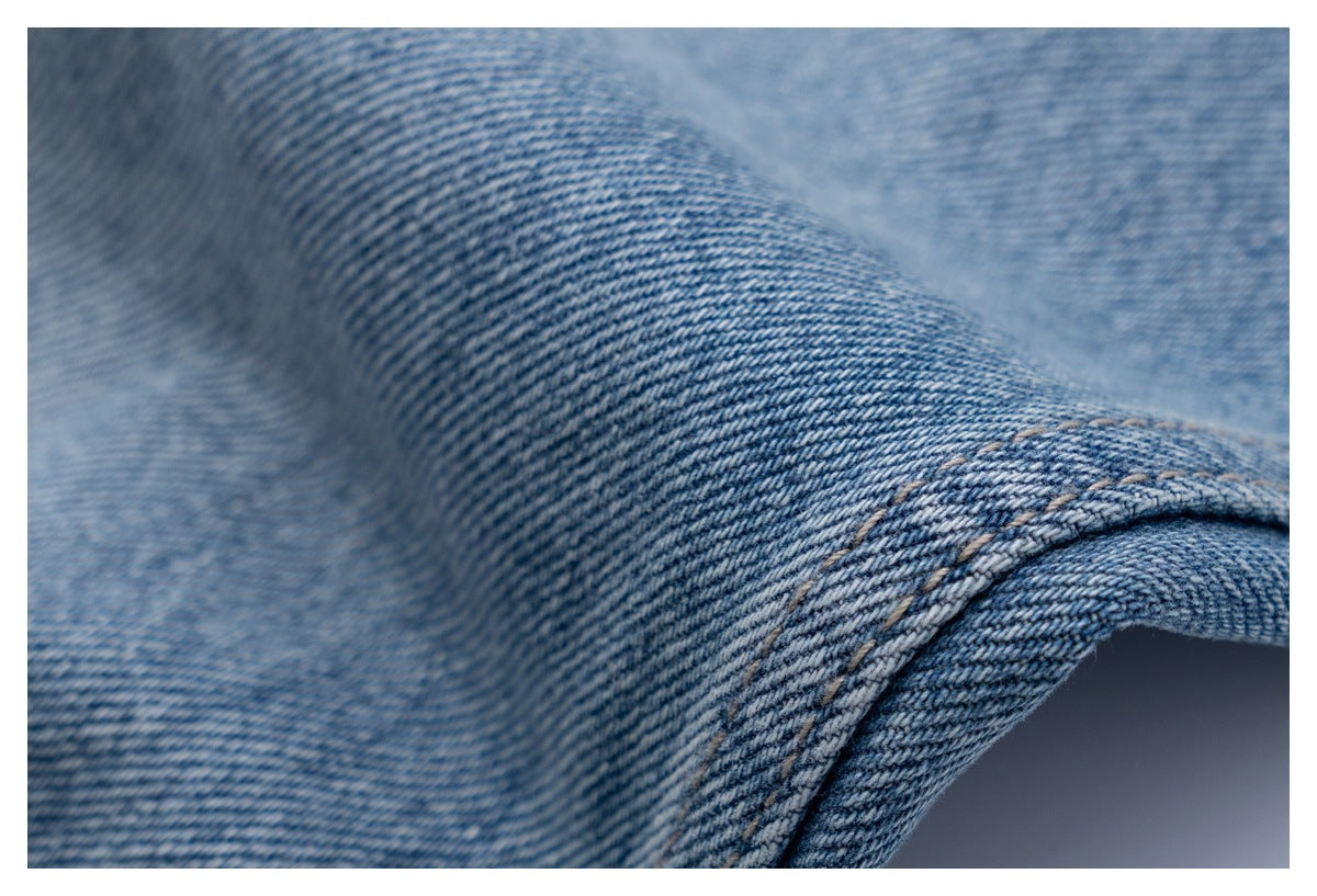 Close-up of light blue denim with a curved double-stitched seam.