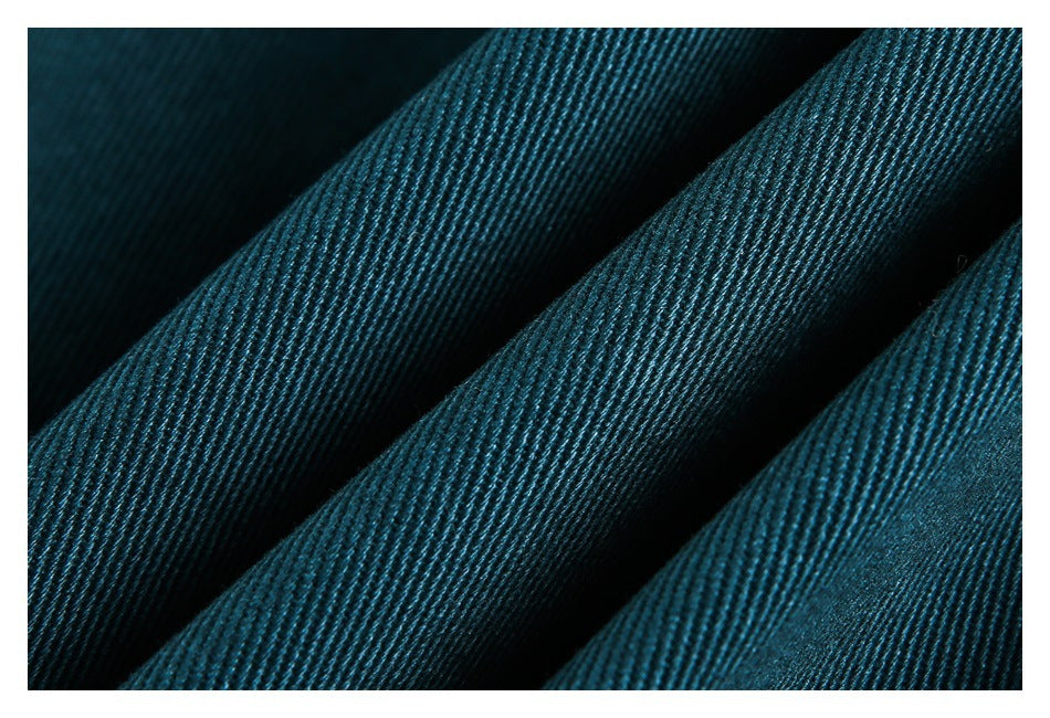Macro view of dark teal ribbed fabric arranged in soft folds.