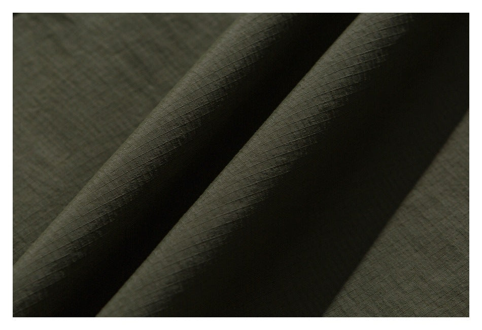 Close-up of olive fabric folds showing its fine grid-like texture.