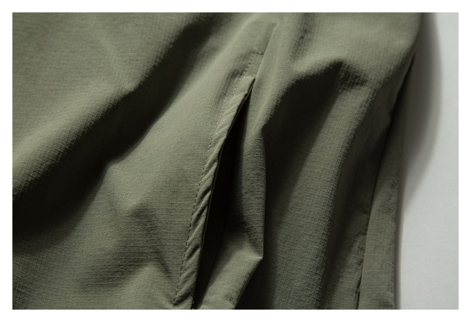 Close-up of an opening in olive-green fabric, showing the folded edge and stitching.