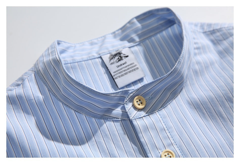 Close-up of the shirt’s striped band collar, beige button and sewn-in neck label.