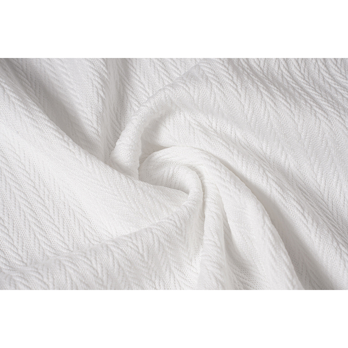 Close-up of white fabric showing a raised, repeating textured pattern.