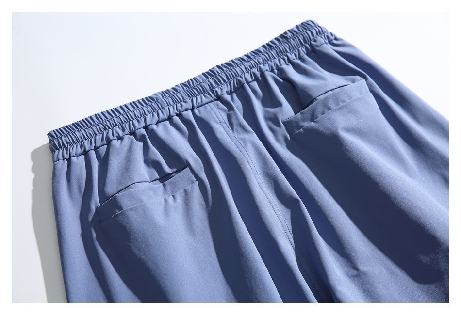 Blue shorts laid flat, showing the gathered elastic waistband and two front pockets.