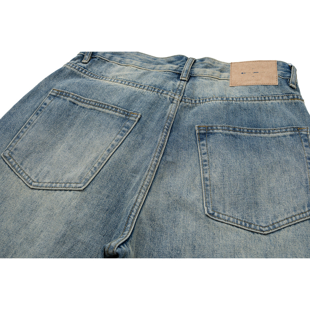 Close-up of the back waistband and two pockets on faded blue jeans, with a tan patch at the waist.