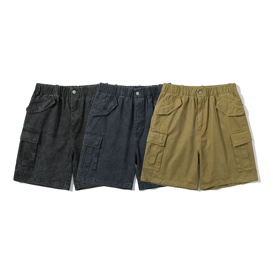 Three front views of cargo shorts in black, charcoal, and olive, with elastic waistbands and flap pockets.