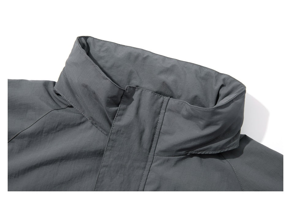 Close-up of a charcoal-gray jacket’s tall collar and front closure flap.