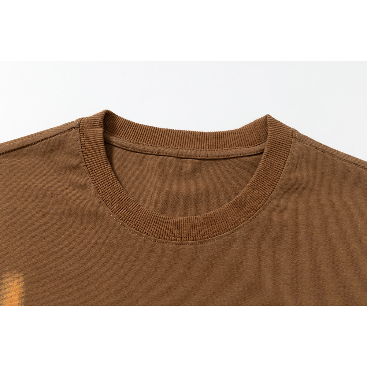 Close-up of a brown T-shirt's ribbed crew neck and shoulder seams.