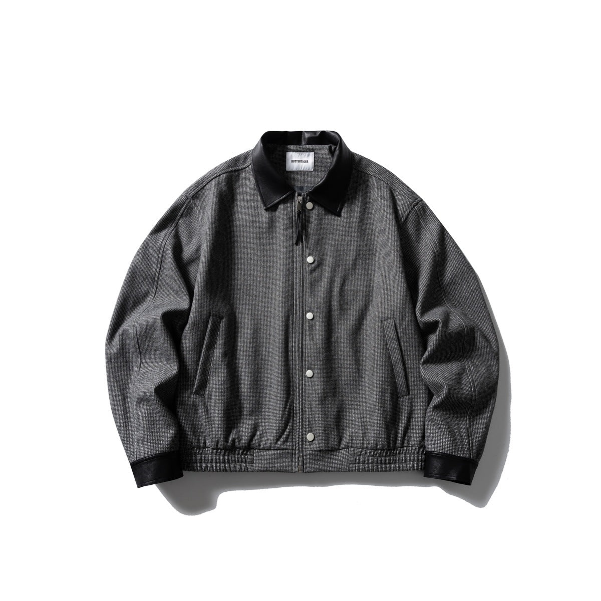 Charcoal gray small-check zip jacket with black leather-look collar and cuffs, snap buttons and elastic hem, flat lay
