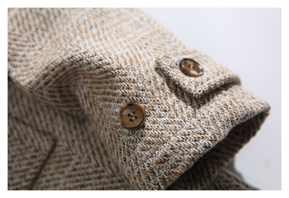 Close-up of a brown button on the tan, cream, and dark flecked tweed coat.