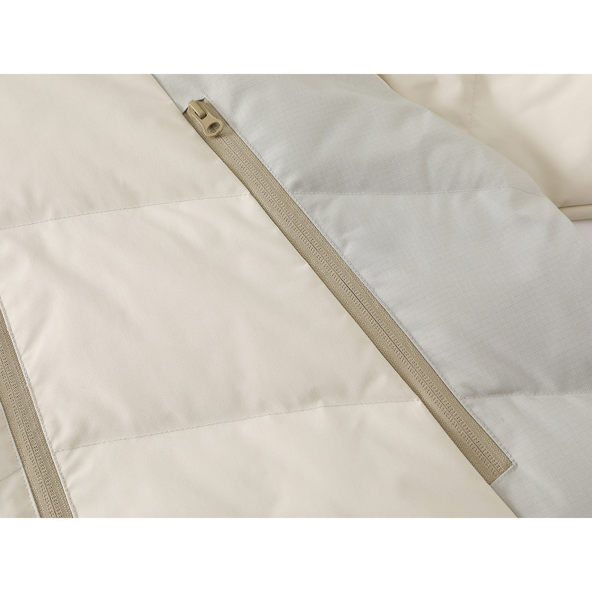 Close-up of the beige front zipper and contrasting pale gray and off-white jacket panels.