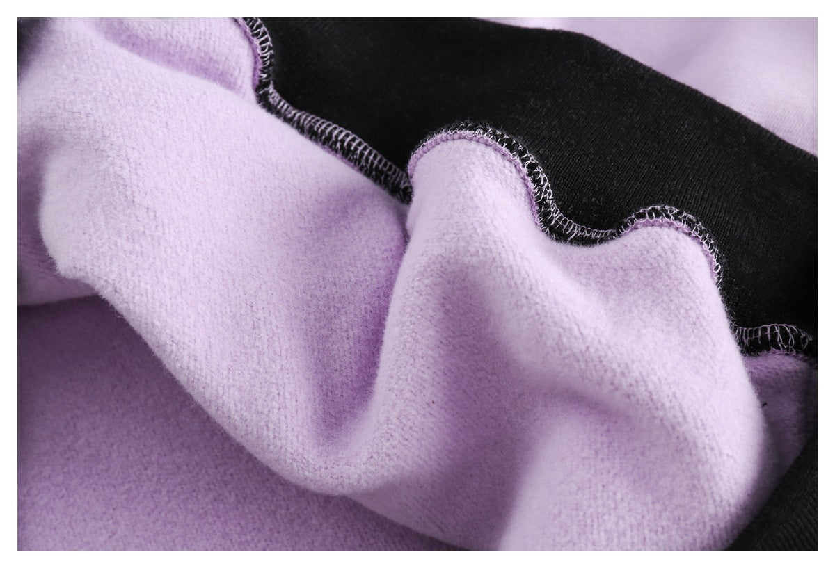 Close-up of lilac brushed inner fabric and overlocked seam against black fabric.