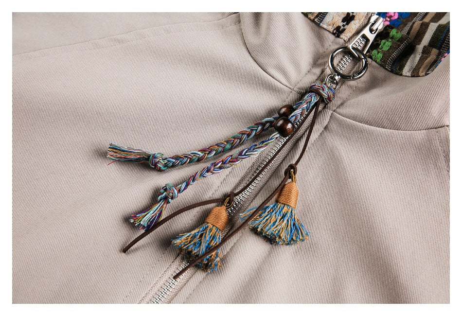 Close-up of braided multicolor cords and tassels attached to the zipper of a beige jacket.