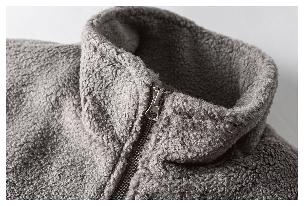 Close-up of a gray textured jacket's tall collar and partially zipped front.