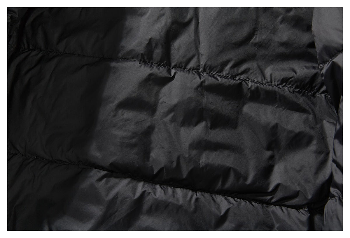 Close-up of black quilted puffer fabric with horizontal stitched channels.