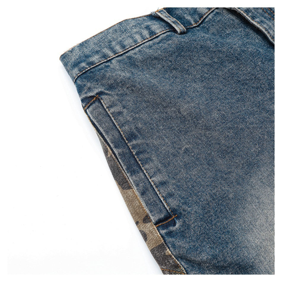 Angled close-up of a blue denim side seam and pocket opening with faded wash details.