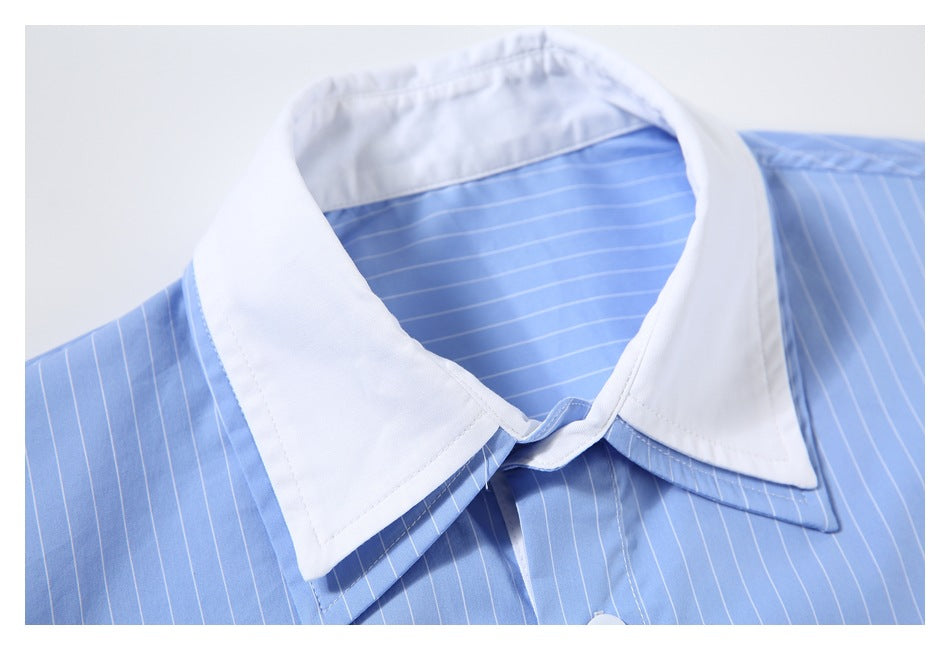 Close-up of a white pointed collar on a light blue pinstriped shirt.