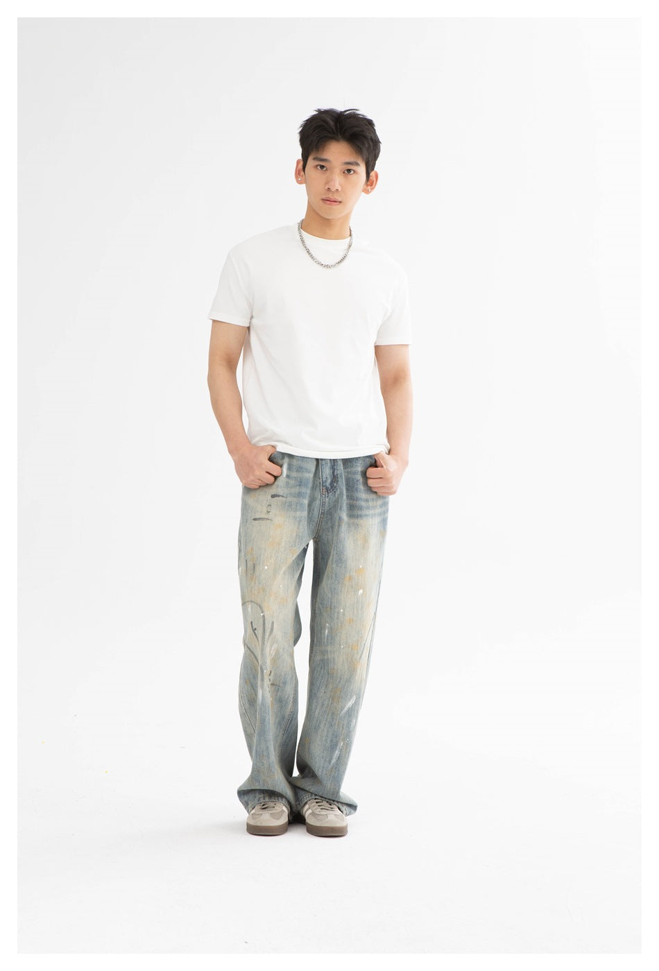 Front view of a model wearing a plain white crew-neck T-shirt and loose, distressed light-wash jeans.