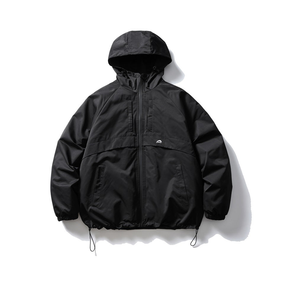 Black hooded zip-up jacket laid flat, closed, with chest pockets, front pockets and drawstring hem