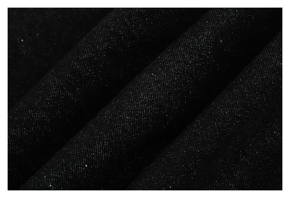 Macro view of the dark black denim weave and subtle diagonal texture.