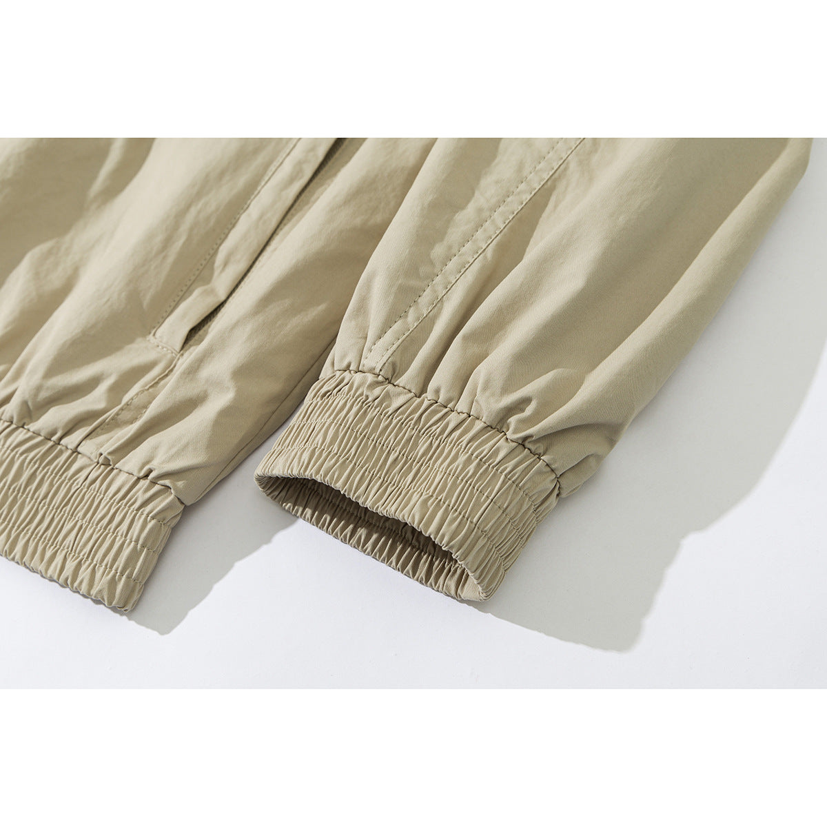 Close-up of a beige jacket's long sleeves and gathered elastic cuffs.